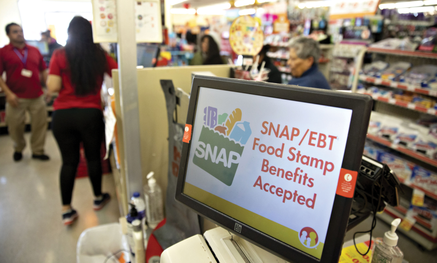 Grocery store monitor that reads "SNAP/EBT Food Stamp Benefits Accepted" inside a Family Dollar.