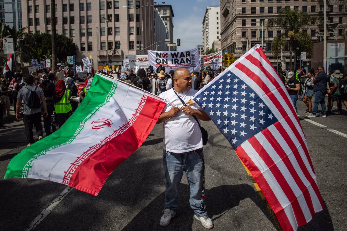 Protester holding both American and Iranian flags in response to the conflict