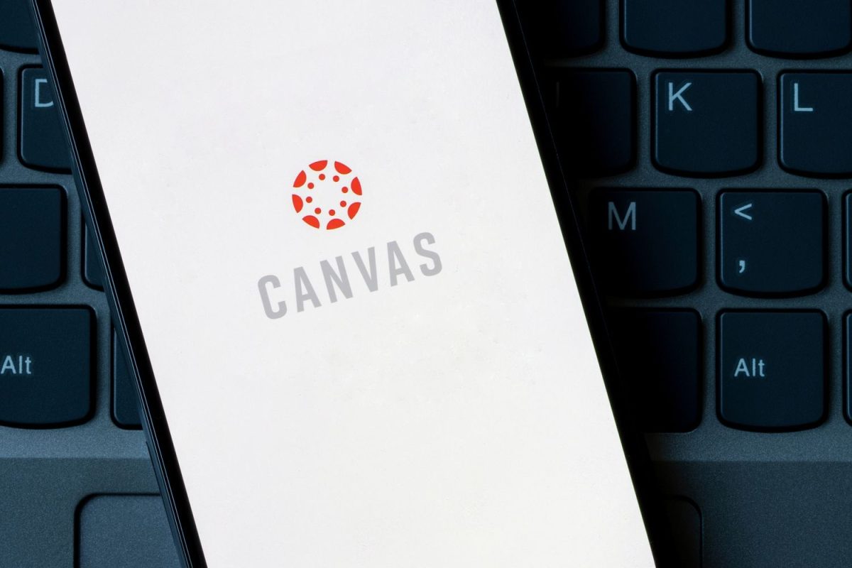 Photo showing the Canvas logo displayed on a phone sitting on top of a laptop keyboard.