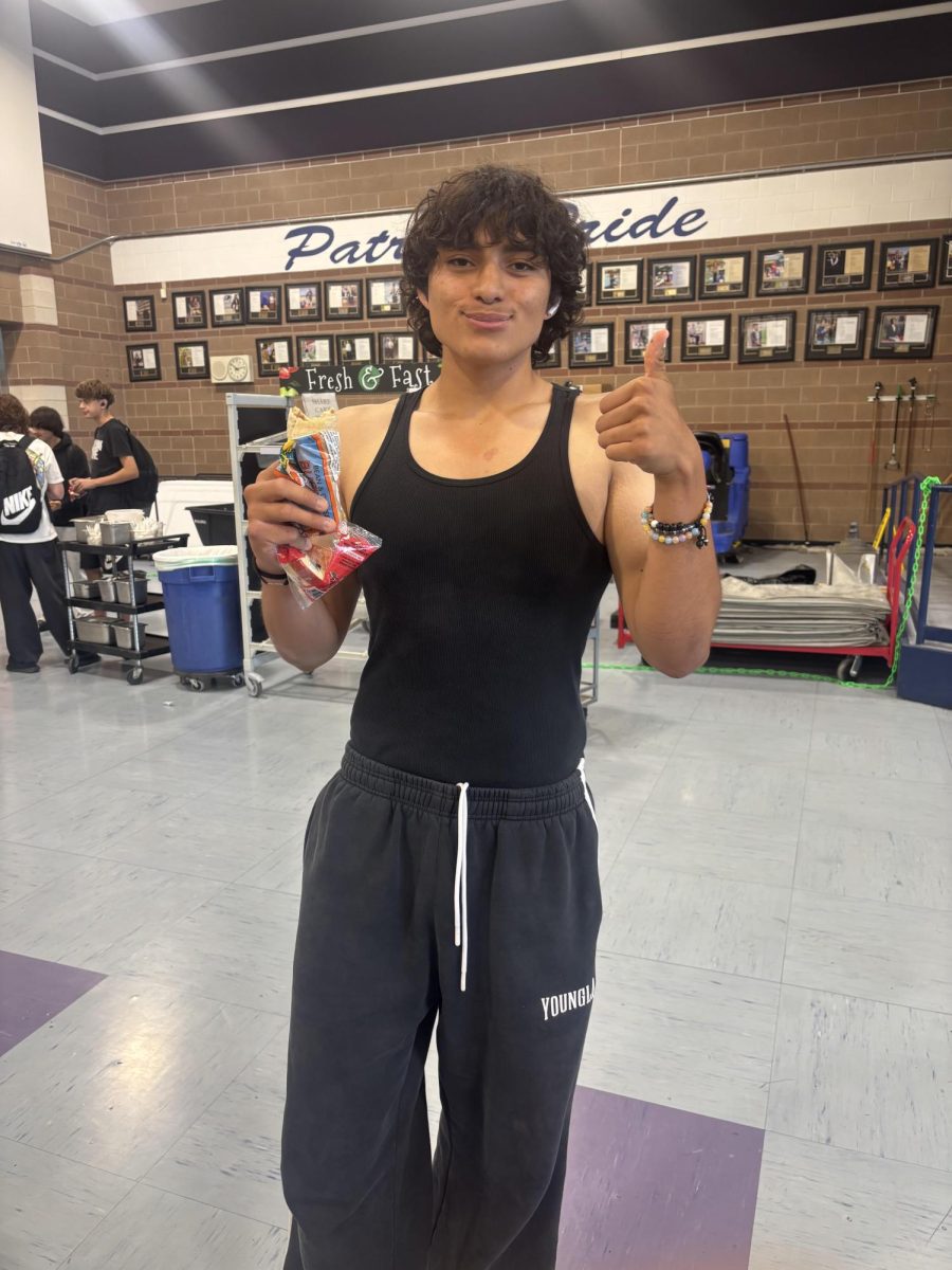 Xavier Sanchez, Liberty High School Sophomore, giving a thumbs up while holding a school lunch, showing how opinions on lunch food can be different from student to student.